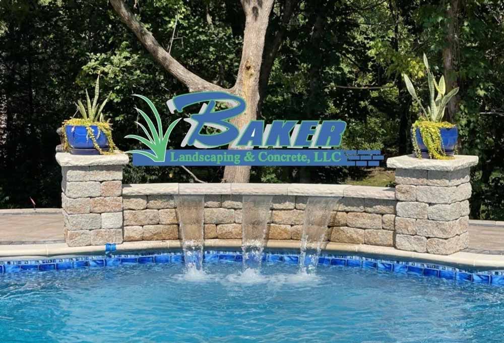 Stone wall with three water spouts flowing into a blue pool