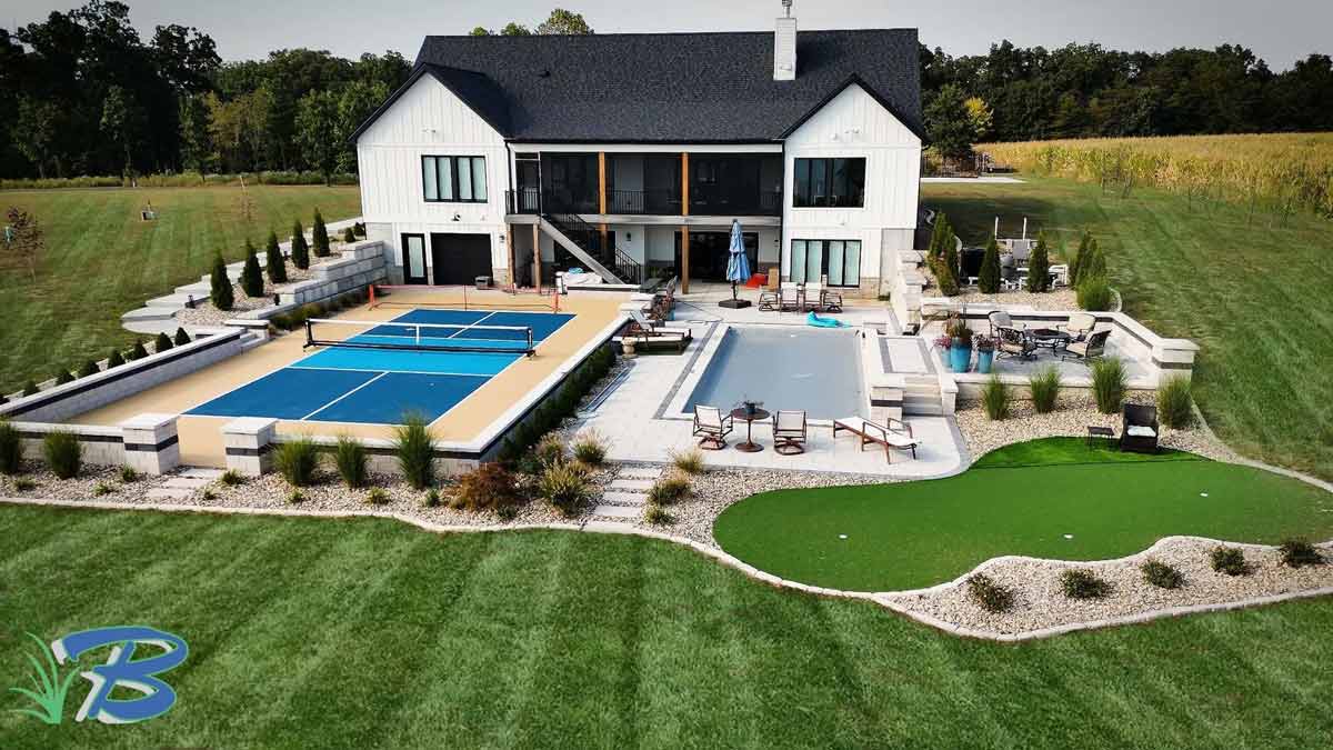 Modern house with pool, pickleball courts, and putting green in landscaped yard