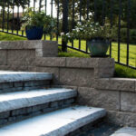 Stone steps along retaining wall with potted plants